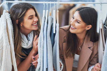 Two happy girls in clothes store during shoppingの写真素材