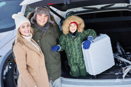 Young family during winter trip car trunk in bacgroundの写真素材