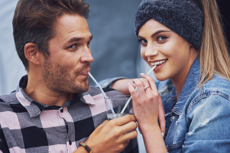 Young nice couple having fun on camping sharing drinkの写真素材
