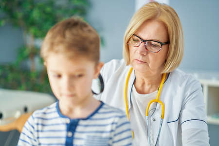 Pediatrician doctor examining little kids in clinicの写真素材