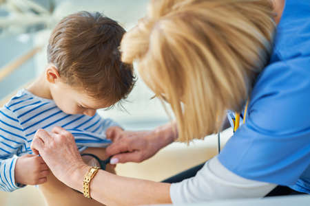 Pediatrician doctor examining little kids in clinic ears checkの写真素材