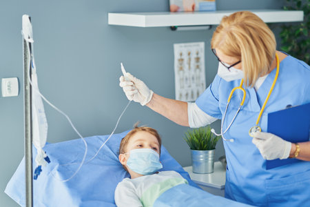 Adult woman and young patient in hospital bedの写真素材