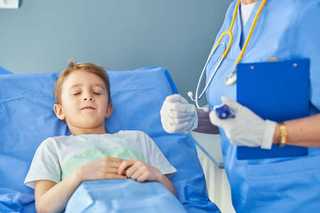 Adult woman and young patient in hospital bedの写真素材