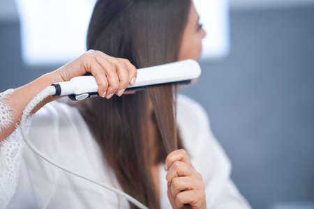 Young nice brunette woman in the bathroom haircareの写真素材