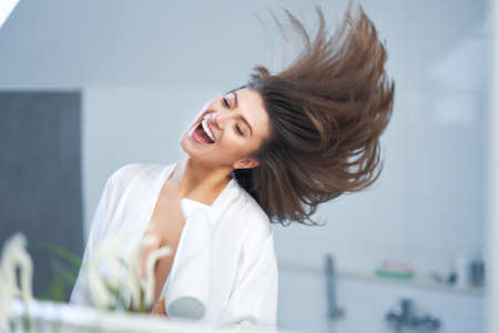 Young nice brunette woman in the bathroom haircareの写真素材