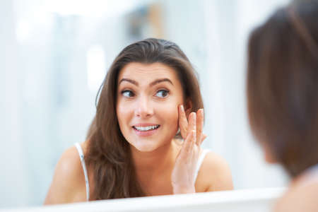 Young nice brunette woman in the bathroomの写真素材