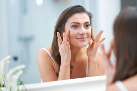 Young nice brunette woman in the bathroomの写真素材
