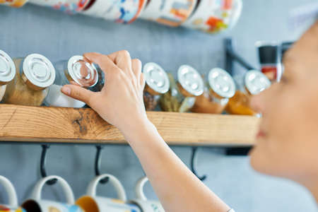 Young woman looking for spices in the kitchenの写真素材