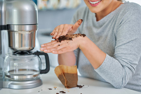 Young woman with coffee grounds use it for peelingの写真素材
