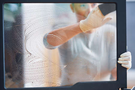 Picture of young woman cleaning fireplace glass doors