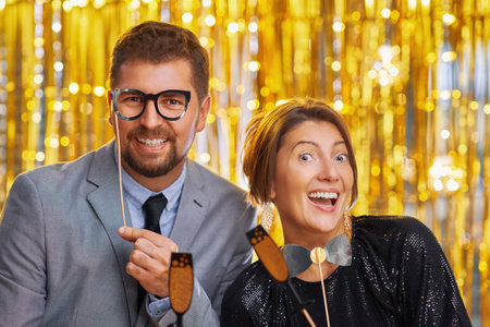 Couple over gold with photo booth accessories on partyの写真素材