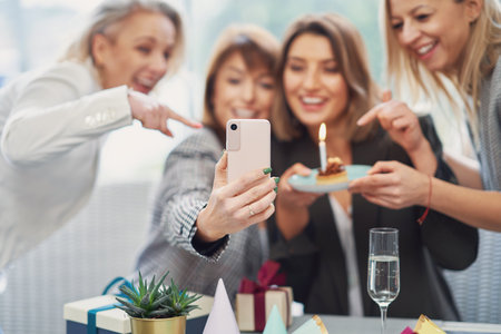 Picture of group of girls with birthday cake taking selfieの写真素材