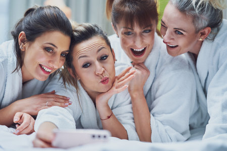 Girls at spa party in hotel with phone