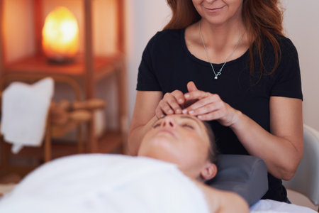 Woman having a face massage treatment in studioの写真素材