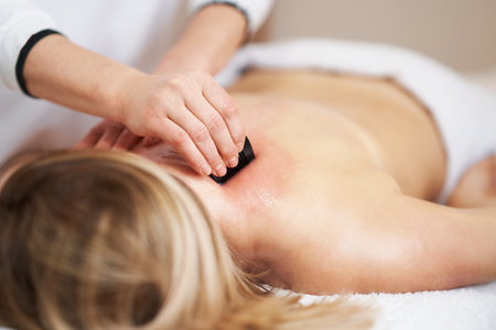 Woman having a gua sha massage in salonの写真素材