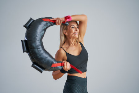 Photo of attractive blonde woman doing training with sandbagの写真素材