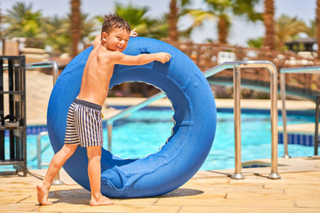 Picture of a small boy having fun in aquapark outdoor on tubeの写真素材