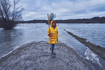 Woman checking water in flood in polish villageの写真素材