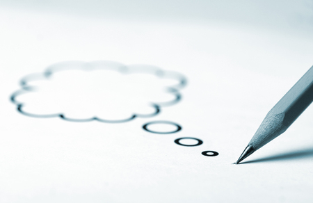 Horizontal close up of a sharp pen with a speech bubble coming out of its top