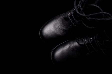A pair of black army boots with shoe laces on black backgroundの写真素材