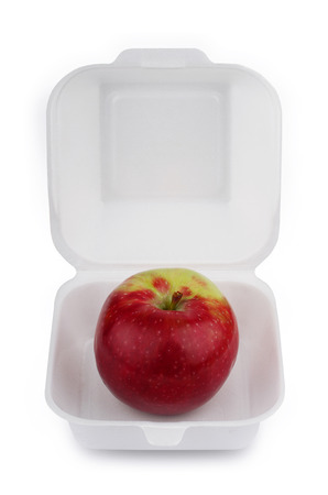 front view of a red apple on open empty white meal foam tray pack isolatedの写真素材
