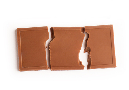 Top view of broken chocolate bar pieces isolated on white backgroundの写真素材