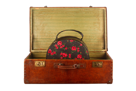 Old vintage open suitcase with roses themed hand luggage isolated on white backgroundの写真素材