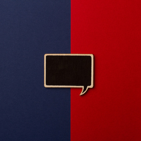 Top view of square empty chalkboard wooden speech bubble on red and dark blue backgroundの写真素材