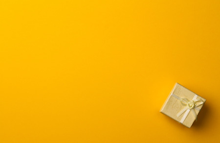 horizontal top view of gift box on minimal yellow background paper texturesの写真素材