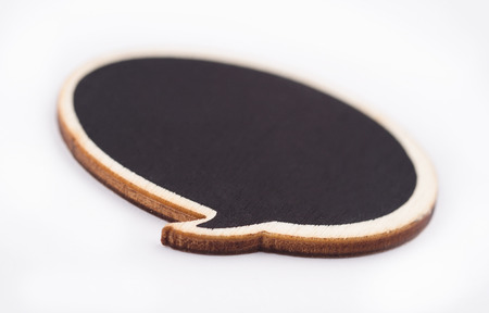 Macro of black handcrafted wooden blank speech bubble on white backgroundの写真素材