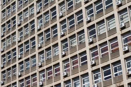 Horizontal front view old of industrial office building windows with air conditioningの写真素材