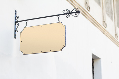 Horizontal front view of empty square vintage signage on a white building with classical architecture hanging with chainsの写真素材