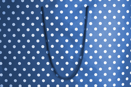 horizontal front view of blue shopping bag background texture with polka dots and textile handle の写真素材