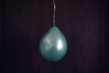 horizontal front view of vintage blue balloon on dark wooden background textureの写真素材