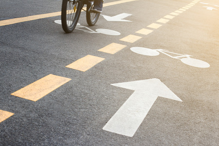 detail of urban city bicycle track with biker in the morning light