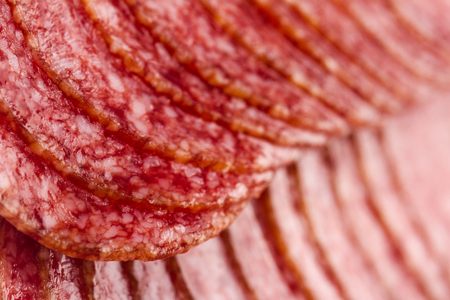 low angle side view detail of smoked salami sausage slices texture selective focusの写真素材