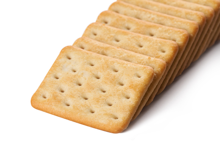 closeup of square shaped salty brown biscuits arranged in rowsの写真素材