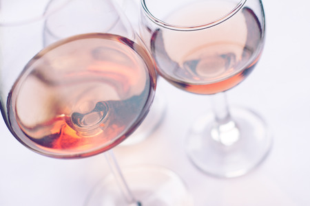 closeup of rose wine glasses of different shapes and sizes with selective focusの写真素材