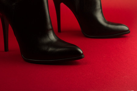 horizontal closeup of high heel woman black leather stylish pair of shoes on red background の写真素材