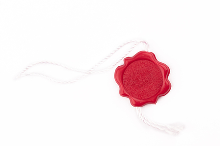 top view of empty red wax plastic seal swing tag with fiber thread and copyspace isolated on white backgroundの写真素材