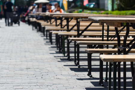 Horizontal view row of empty restaurant terrace tables outdoor setting in summer on stone streetの写真素材