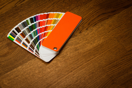 top view of multicolor color paper sampler open on brown wooden floor with copyspaceの写真素材