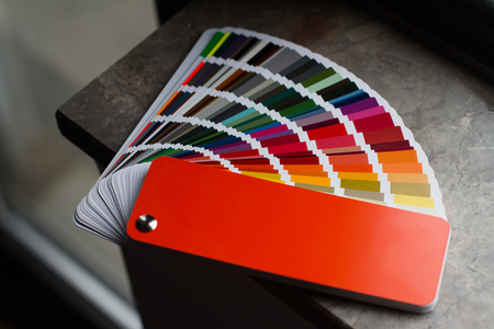 top view of multicolor color paper sampler open on dark marble window sill in natural lightの写真素材