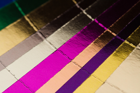 front view close up of multicolor color stamping hotfoil paper spectrum sampler isolated on white backgroundの写真素材