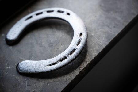 top view of steel polished horseshoe in natural light on a marble stone window sill の写真素材