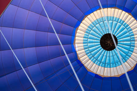 front view detail closeup of the colorful fabric interior texture of a hot air balloon during flightの写真素材