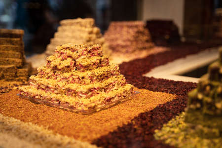 rows of Turkish delight sweets desserts with dried fruits arranged in a pyramid and lined up in the store windowの写真素材
