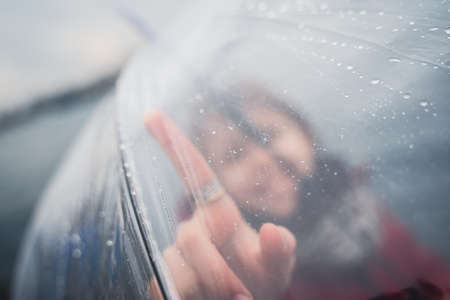 front view closeup portrait of happy little girl dressed in red and holding a transparent umbrella...