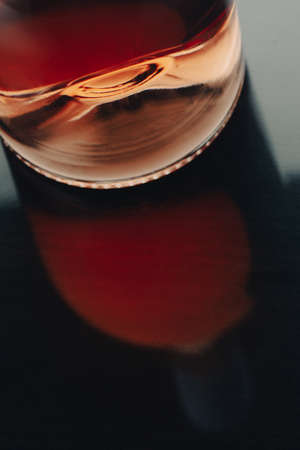 front view closeup of a rose wine bottle punt with reflection on shiny dark surfaceの写真素材