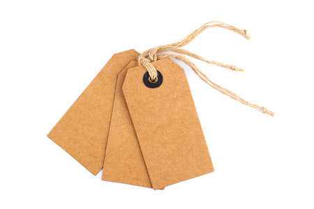 top view closeup of three vintage blank craft paper tags with textile thread isolated on white...